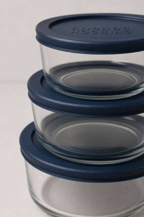 Close‑up side view of Anchor Hocking round glass containers with navy blue SnugFit lids