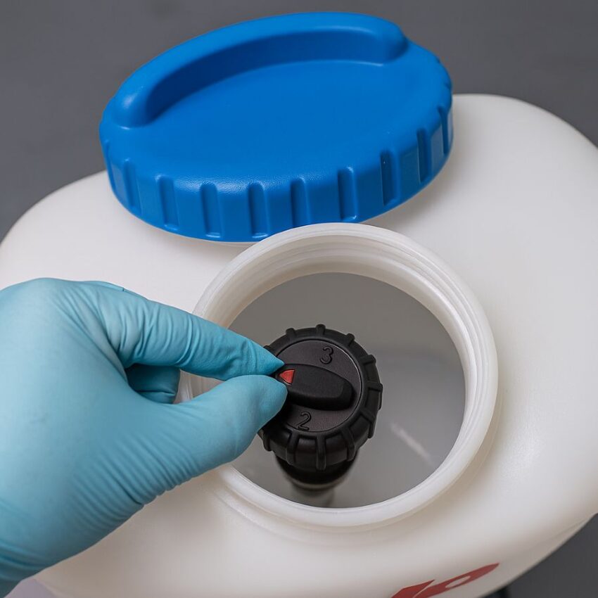 Gloved hand setting the SOLO regulator inside the tank before filling