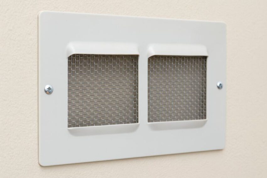 Stainless 10-mesh panel fastened behind a wall vent to allow airflow while blocking pests.