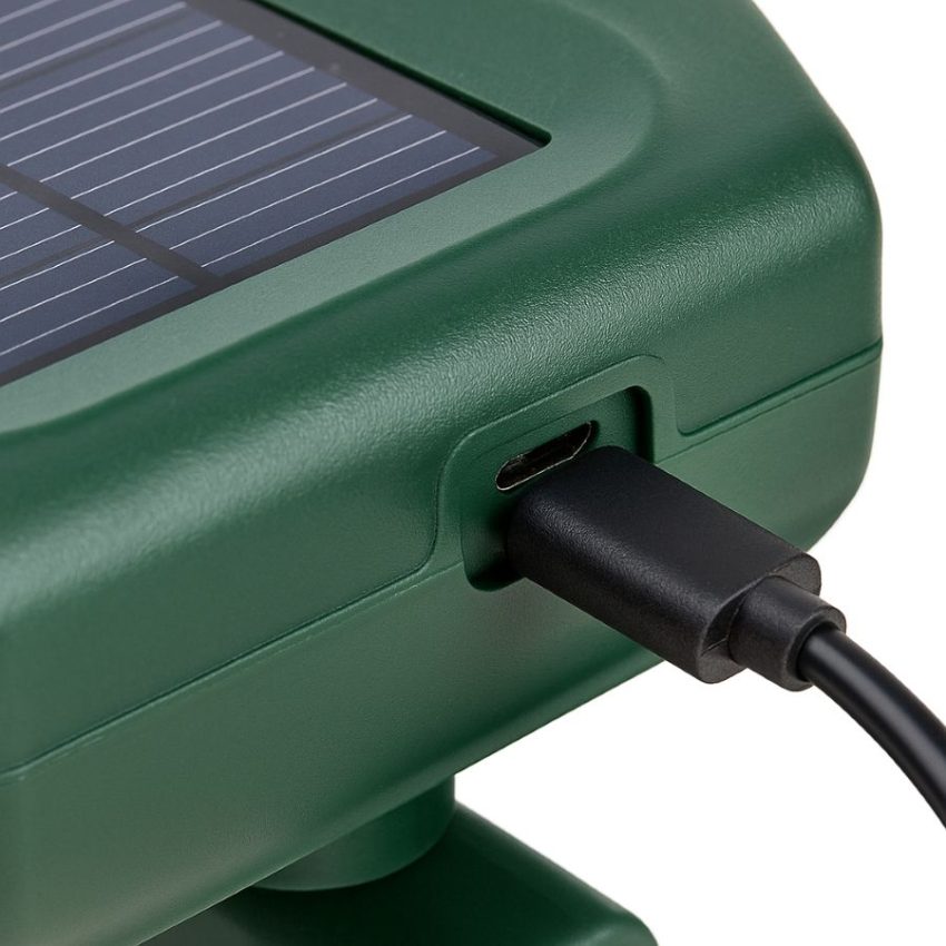 Close up of USB cable topping up the solar ultrasonic repeller after cloudy weather